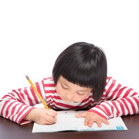 宿題をがんばる前髪パッツンの女の子の勉強風景の写真
