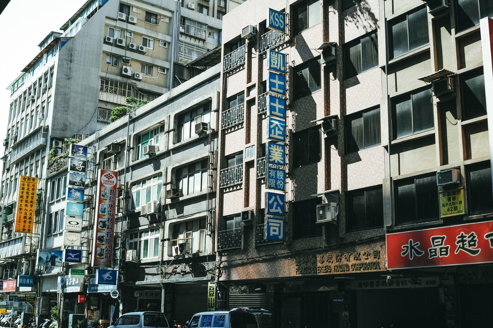 台北の古いアパート建物に取り付けられた色とりどりの商店街看板