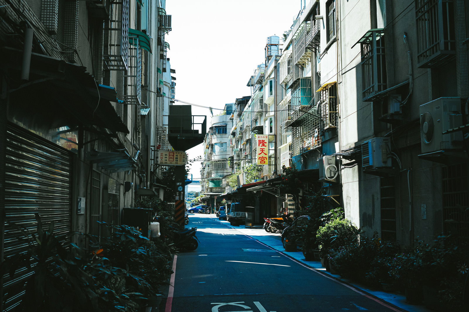 台湾サンチョンの住宅街の狭い路地に青いバイクが駐車された風景