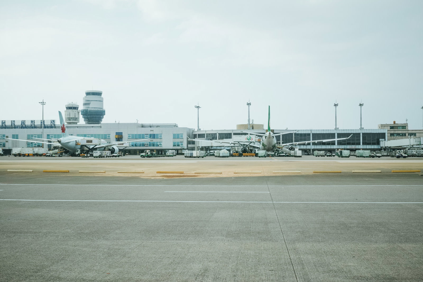 台湾桃園国際空港の滑走路に駐機する白い旅客機の後姿