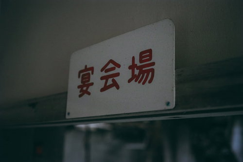 昭和の風情漂う宴会場入口の看板と旅館の素朴な文字デザイン