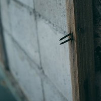 トラップのように柱から危険に突き出す錆釘の写真