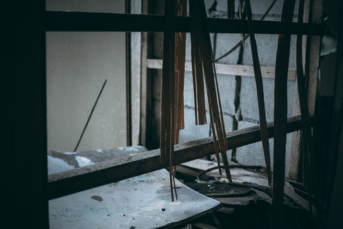 思い出と共に崩れていく木材の壁板と割れた窓ガラス
