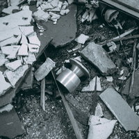 廃墟に散乱する錆びたドアノブと瓦礫、破壊されたコンクリート破片の写真