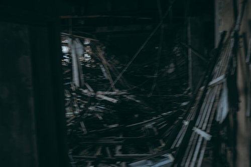 廃墟の中、必死に逃げ惑う人物 - 瓦礫散乱の暗闇