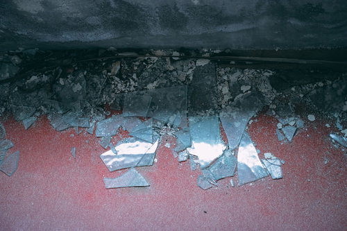 床に散らばった割れたガラス片と破片の危険な状態