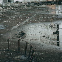 忘れられた景色を無情に映す水たまりと瓦礫の写真