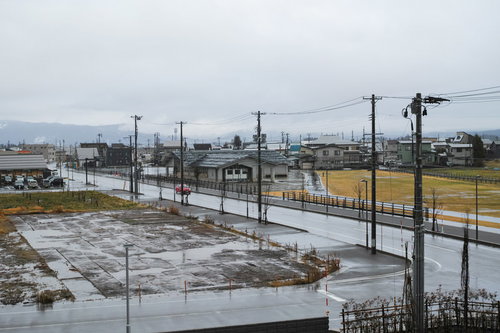 雨降る住宅地の街並みと濡れた道路、電柱の風景