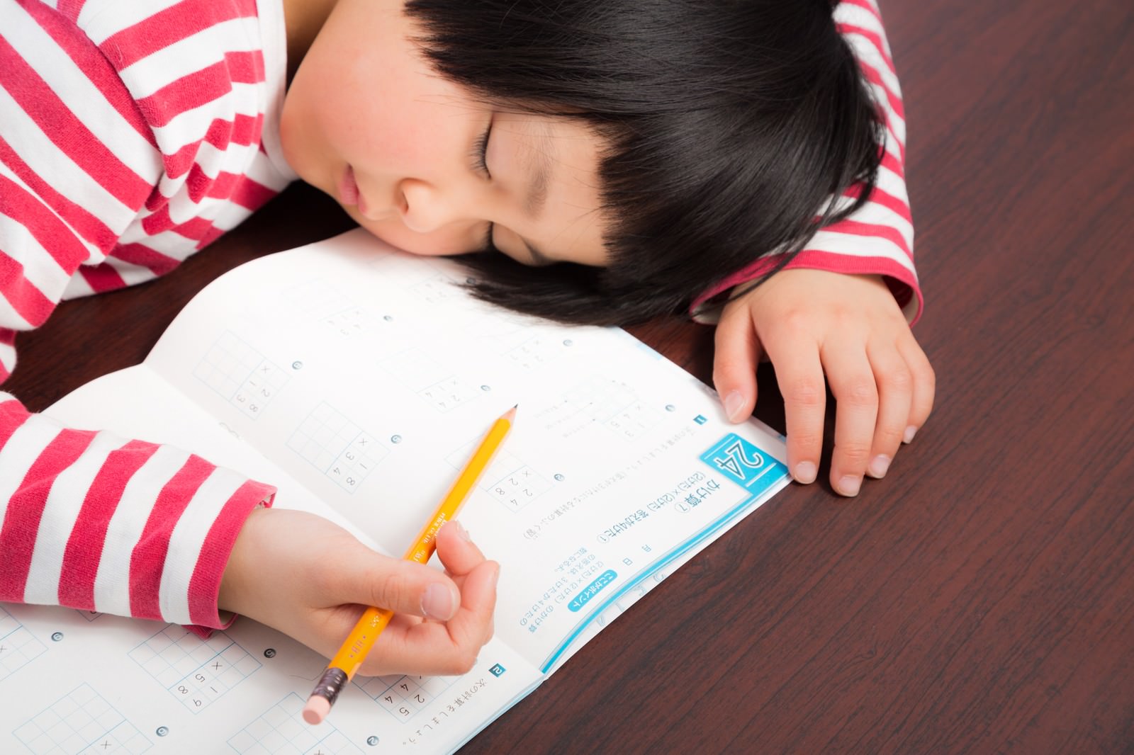 勉強机で宿題しながら眠ってしまった前髪パッツンの女の子［モデル：ゆうき］