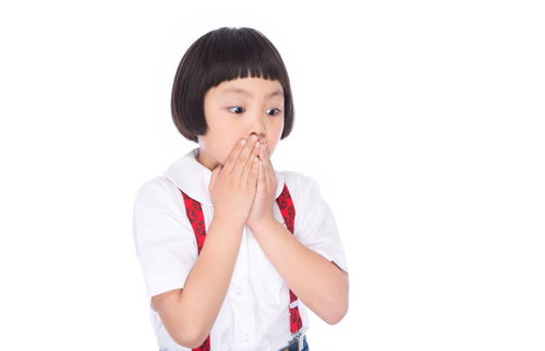 両手で口を塞ぎ驚いた表情で何かを見つめる小学生女の子