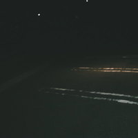 深夜の駐車場に白線で区切られた駐車スペースの写真