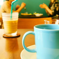 カフェのテーブルでコーヒーカップを手に一休みする時間の写真