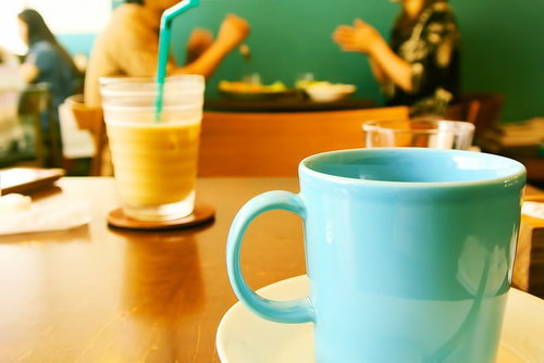 カフェのテーブルでコーヒーカップを手に一休みする時間