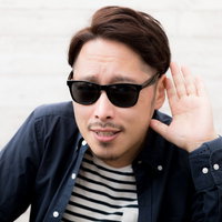 サングラスをかけて芸能人気取りで聞き直す男性の写真