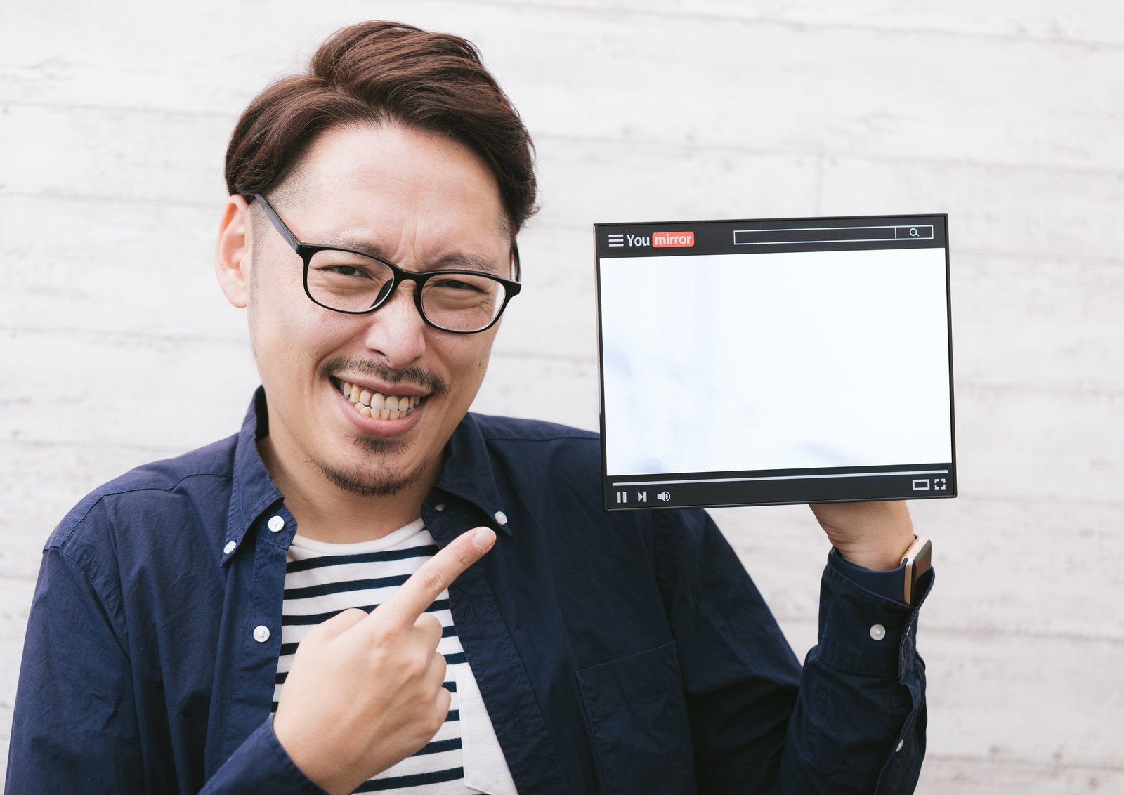 タブレットを持って笑顔でポーズを取る眼鏡をかけた男性［モデル：ゆうせい］