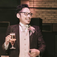 乾杯の挨拶でシャンパングラスを掲げる新郎の写真