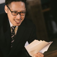 怪しい儲け話を持ちかけてくるスーツ姿の男性の写真