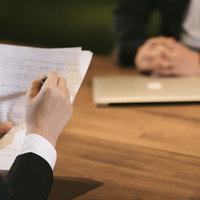 資料を手に打ち合わせする男性の写真