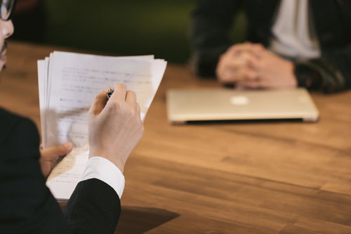 資料を手に打ち合わせする男性