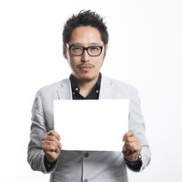 営業先にヒッチハイクで行けるか挑戦している男性がホワイトボードで情報を提示の写真