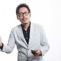 感情がこみ上げぐっとコブシを握るプレゼン中の男性の写真