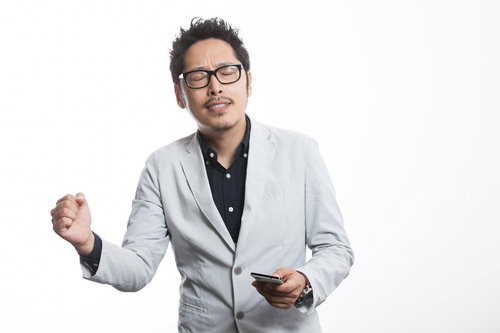 感情がこみ上げぐっとコブシを握るプレゼン中の男性