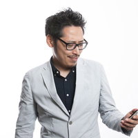 スマホでランチのメニューをチェックするディレクター男性の写真