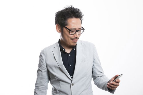 スマホでランチのメニューをチェックするディレクター男性