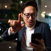 スマホで飲食店を案内する上司、地図アプリで夜間の道案内の写真