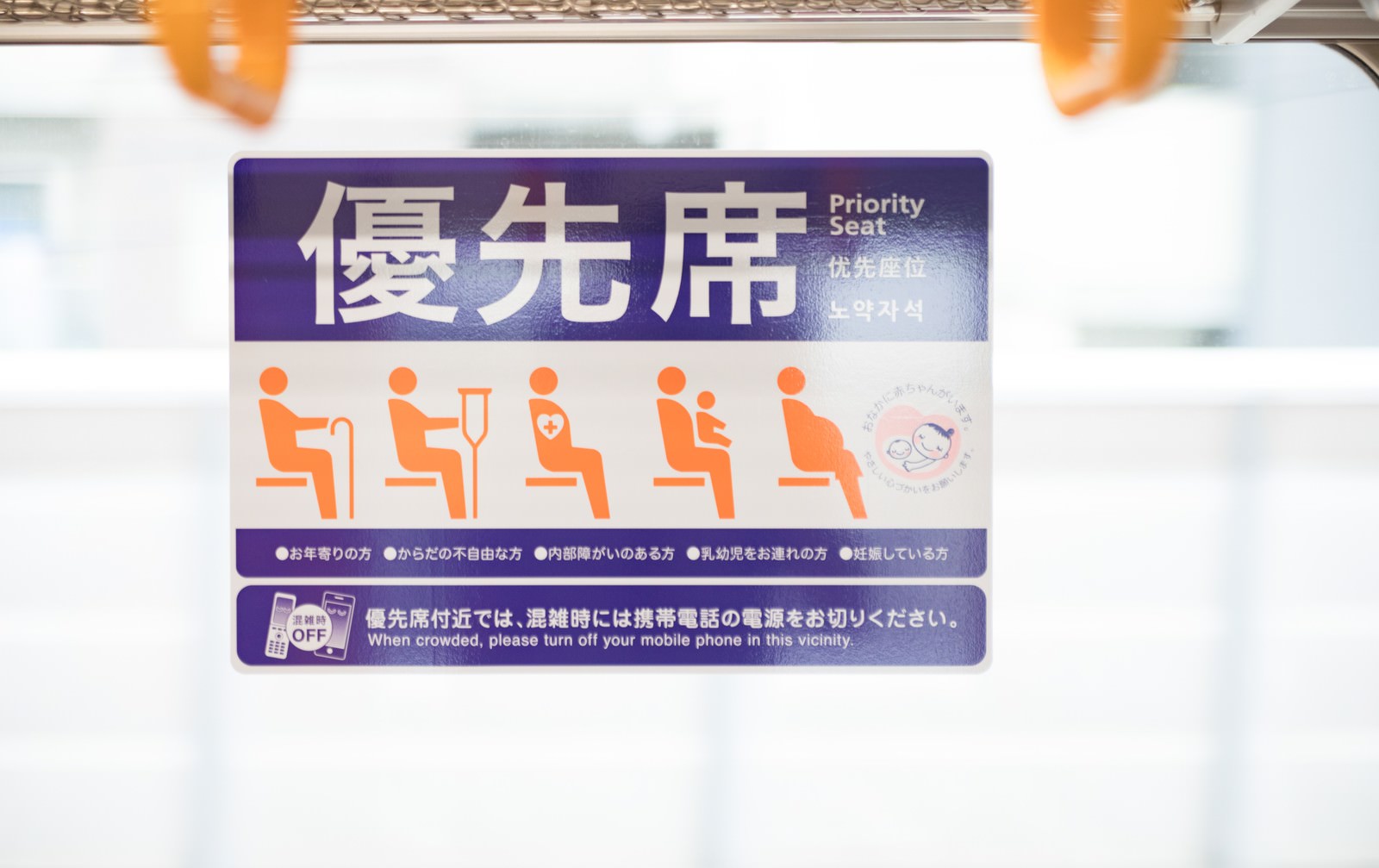紫色の電車の優先席に優先席マークが表示されている様子