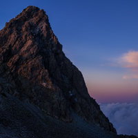 日没後の残光に淡く照らされた槍ヶ岳と北アルプスの雲海の写真