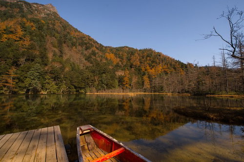 晩秋の上高地・明神池に浮かぶ赤いカヌーと北アルプスの黄葉