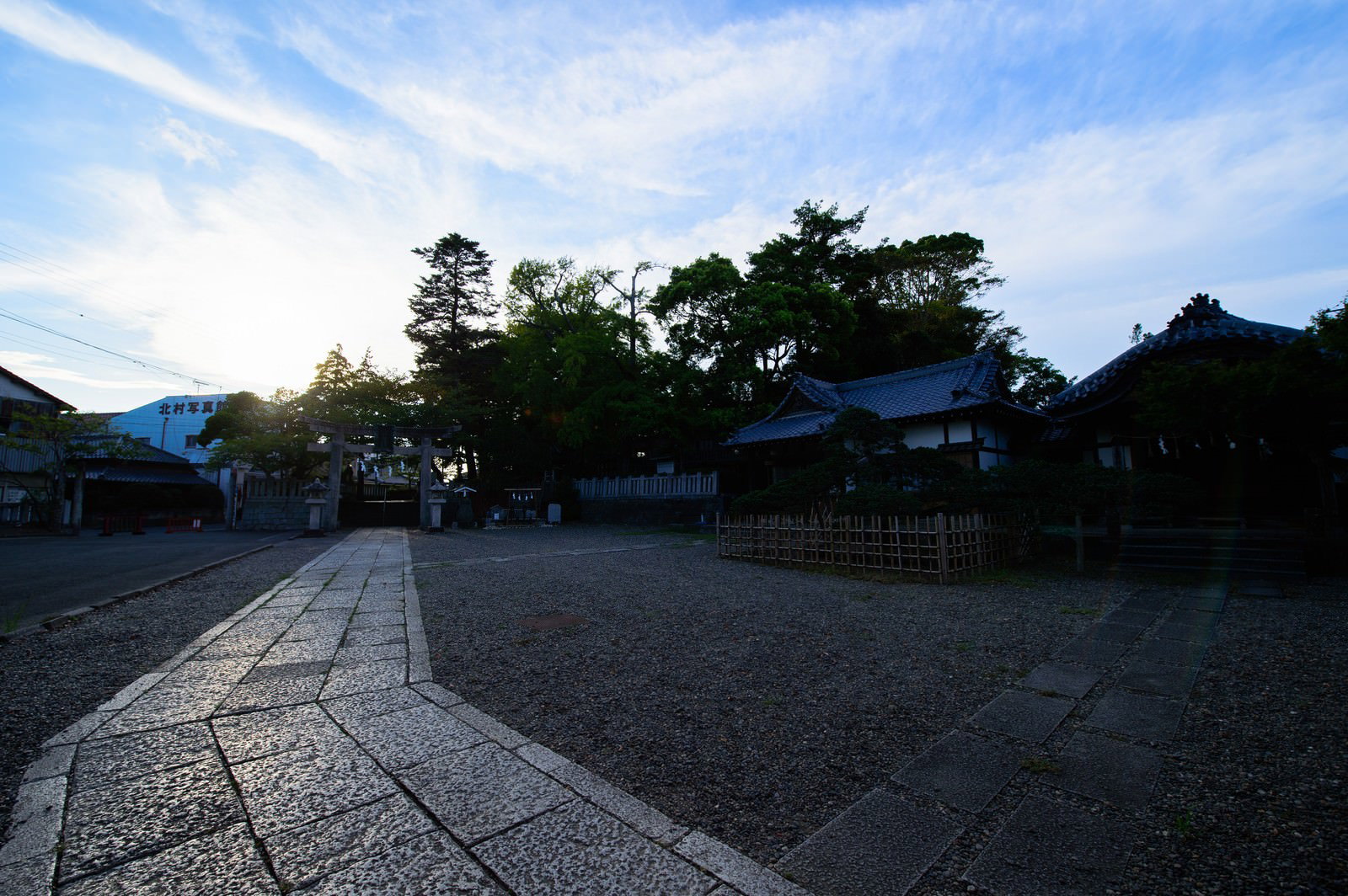 夕暮れ時の玉前神社境内、石畳の参道と鳥居、緑の木々