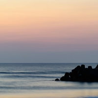 一宮海岸の朝焼けと防波堤、テトラポットに映る薄明の海（千葉県一宮町）の写真