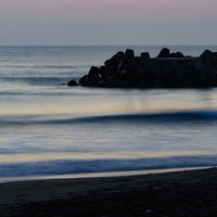 朝焼けに染まる一宮海岸の波打ち際と波消しブロックの写真