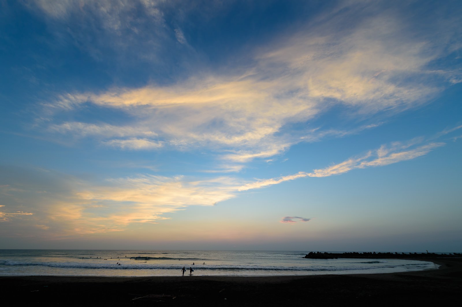 朝焼けの空の下、一宮海岸でサーフィンを楽しむ人々のシルエット
