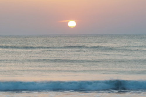千葉県一宮海岸の朝日が海面を照らす波打ち際