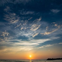 一宮海岸で朝焼けに染まる海へ向かうサーファーの写真