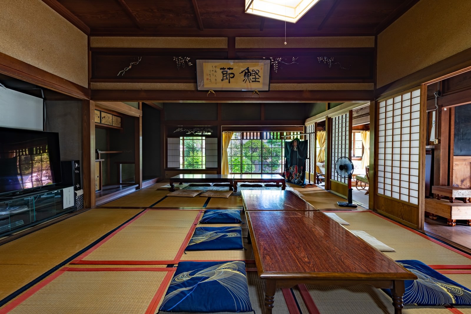 畳敷きの和室に青い座布団が並ぶ古民家の室内