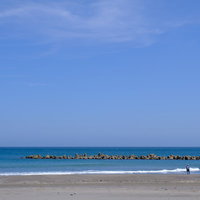 千葉県一宮町の一宮海岸と青空の海岸線、砂浜とサーファーの写真