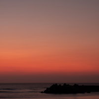 朝焼けに染まる一宮海岸の防波堤のシルエットの写真