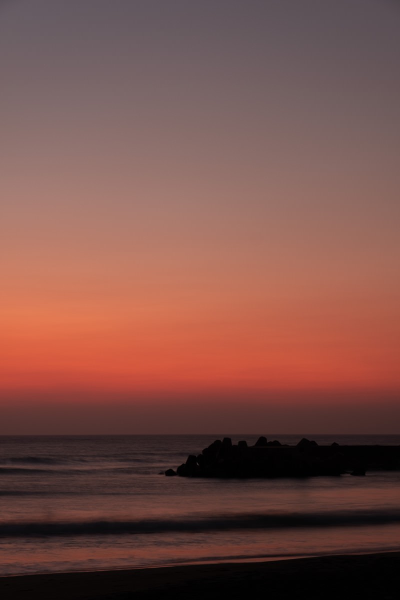 朝焼けの空を背景に一宮海岸の防波堤がシルエットで写る海岸風景