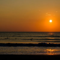 朝日に照らされる砕けた波のシルエット（千葉県一宮町の海岸）の写真