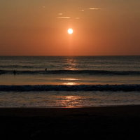 朝日を背に海岸に打ち寄せる波、千葉県一宮町の写真