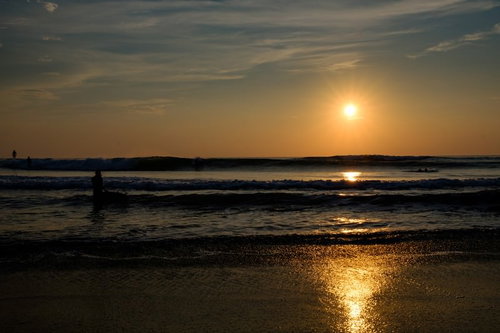 朝日を背に高波に挑むサーファー達の朝焼け風景（千葉県一宮町）