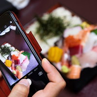海鮮ちらし寿司をスマートフォンで記念に写メする瞬間の写真