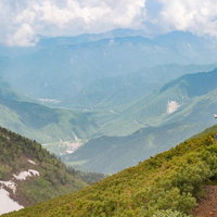 乗鞍新登山道から見える平湯温泉と北アルプスの稜線の写真