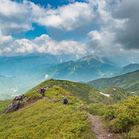 乗鞍新登山道から眺める北アルプスと登山者の写真