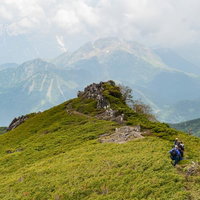 乗鞍新登山道のガスの中から姿を現した焼岳と登山者の写真