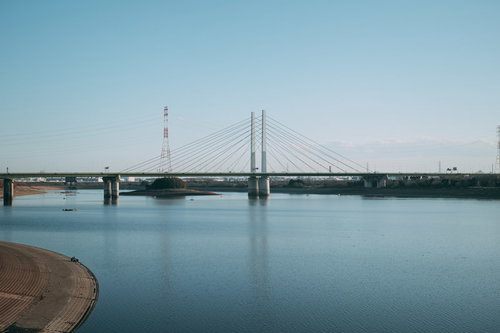 晴れた日の河川に架かる橋と水面への反射